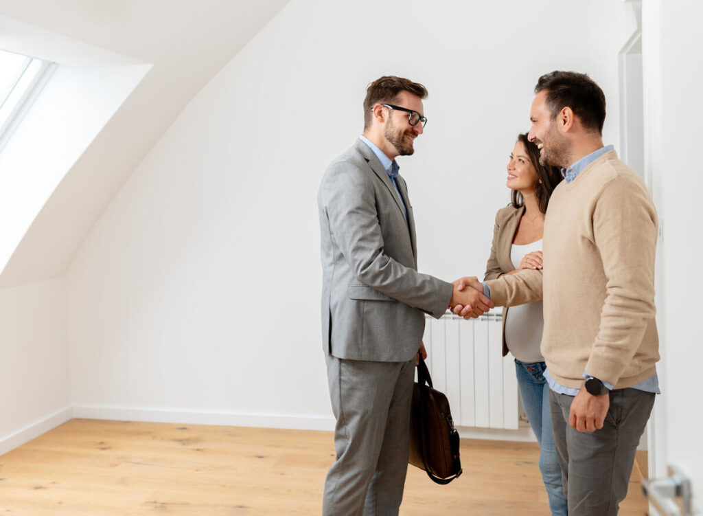 three people are discussing and two are making shake hands.